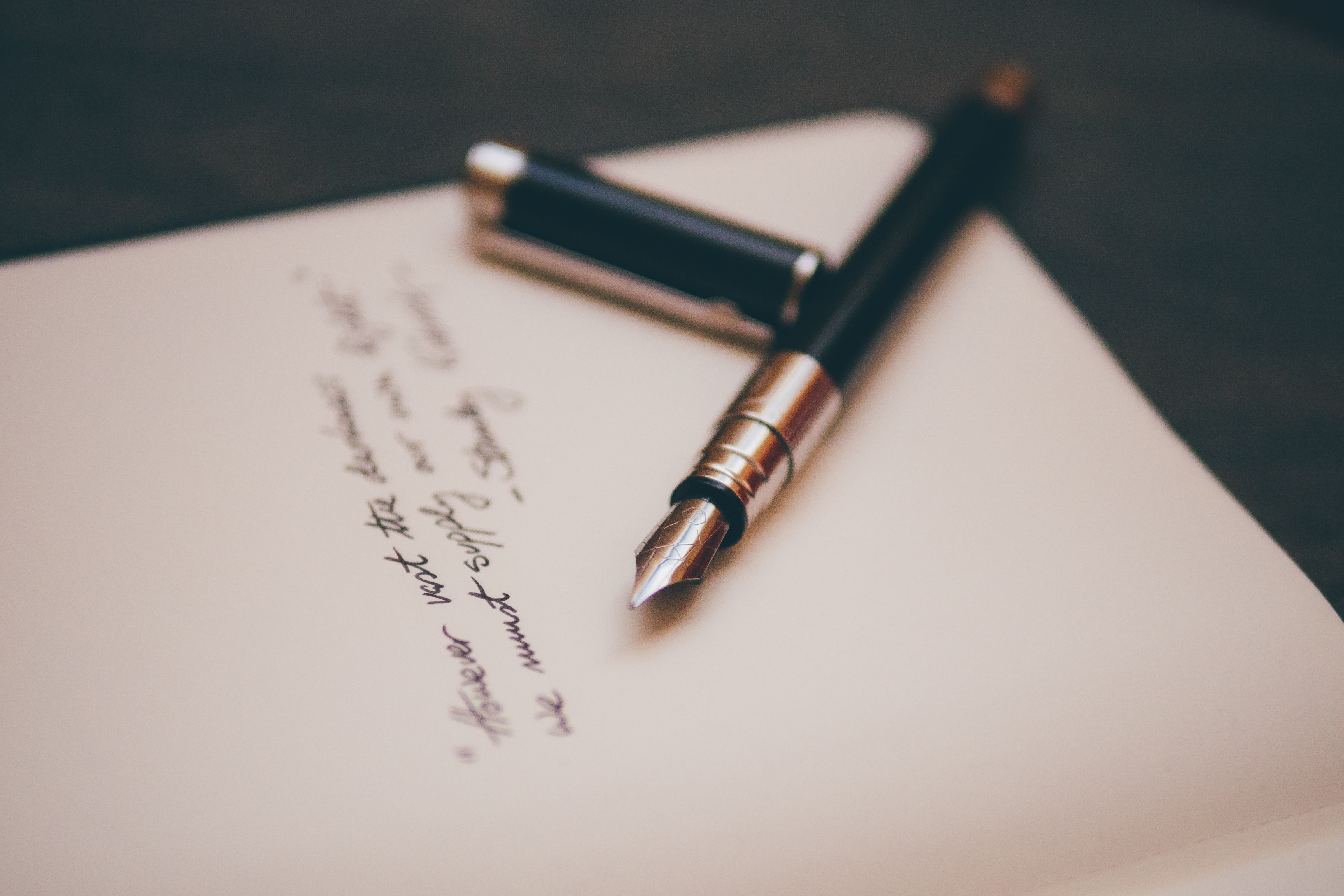 A pen on a sheet of paper with handwritten words