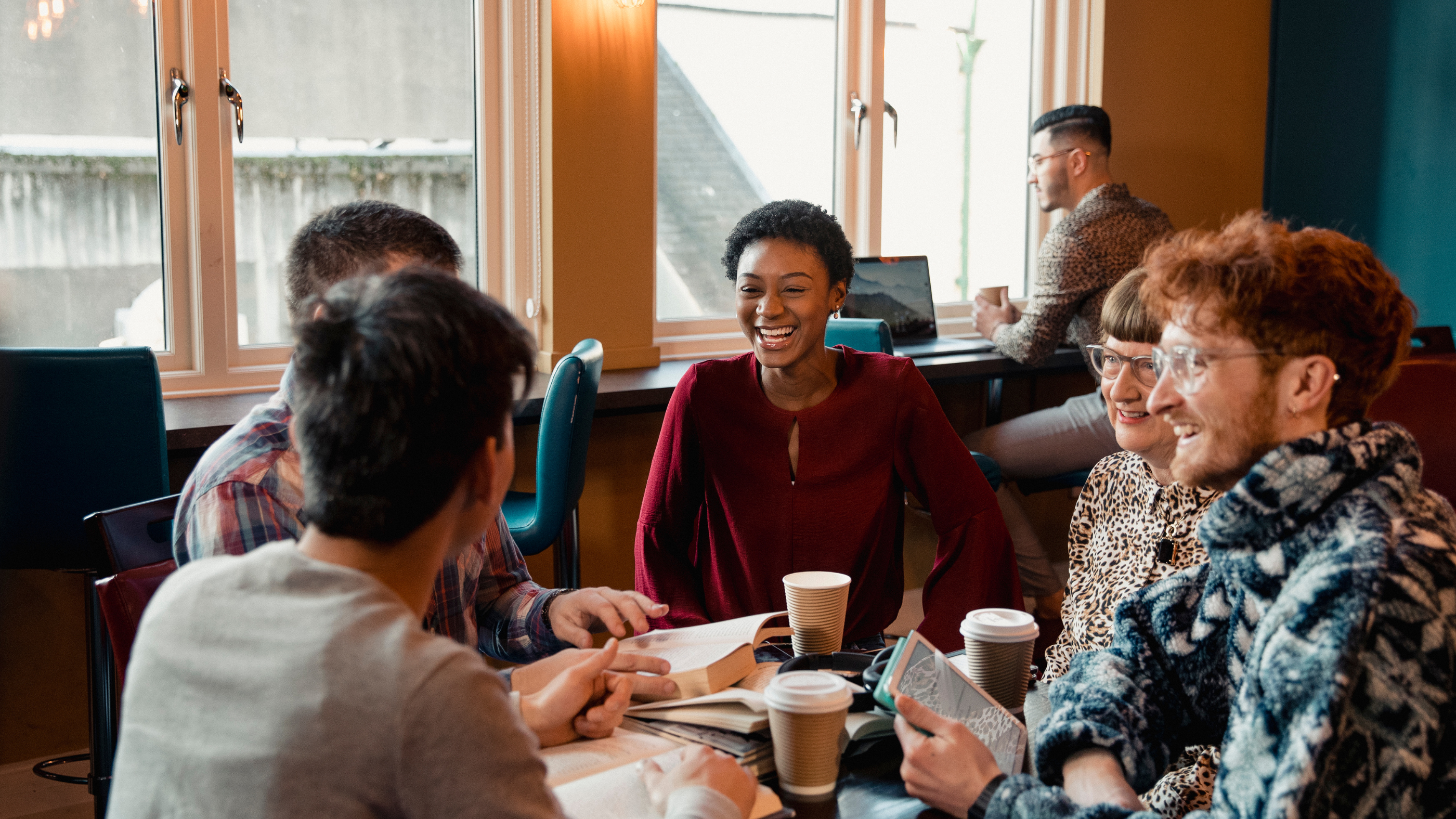 A diverse group of people meeting for a book club in a coffee shop