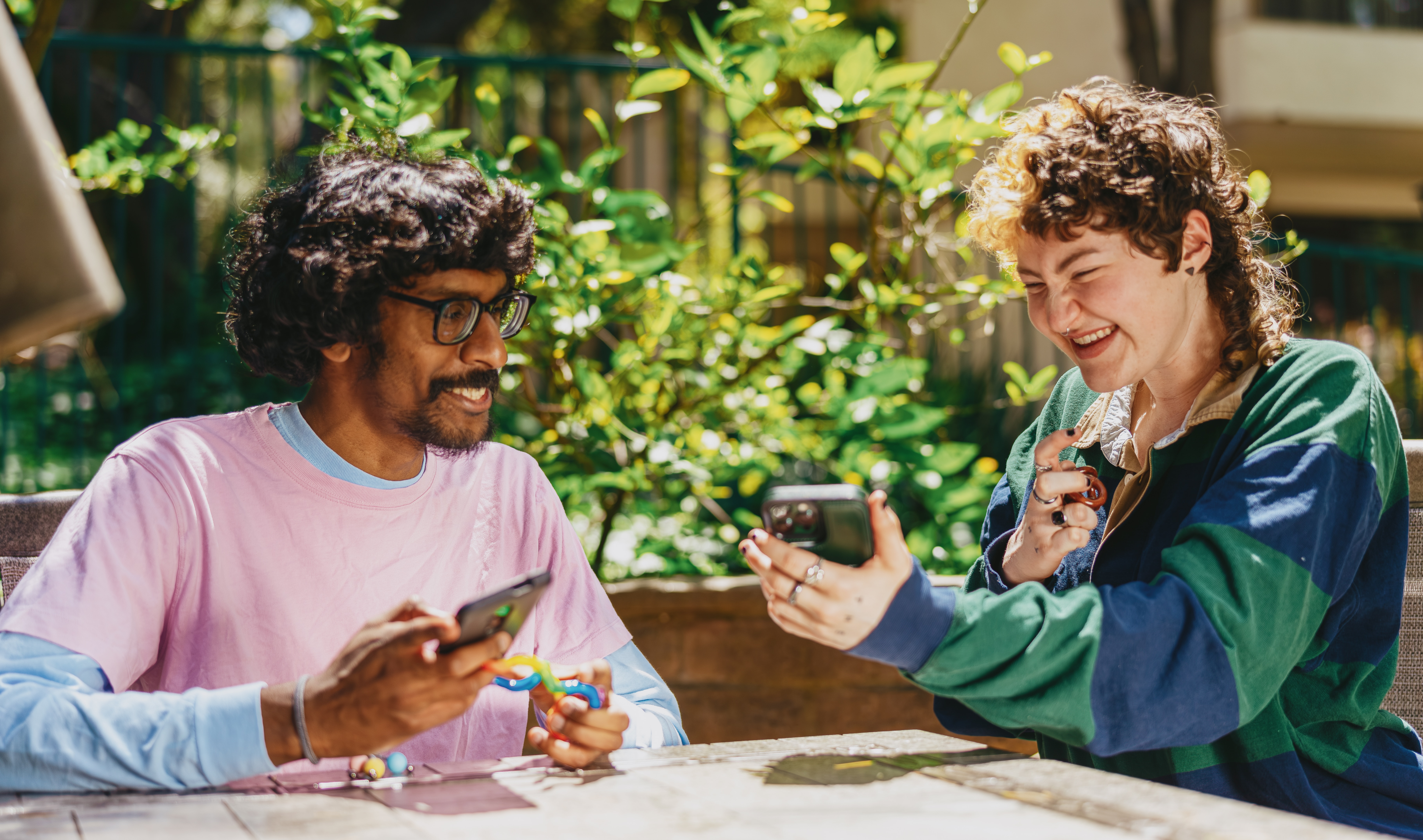 Two friends laughing and playing with fidgets