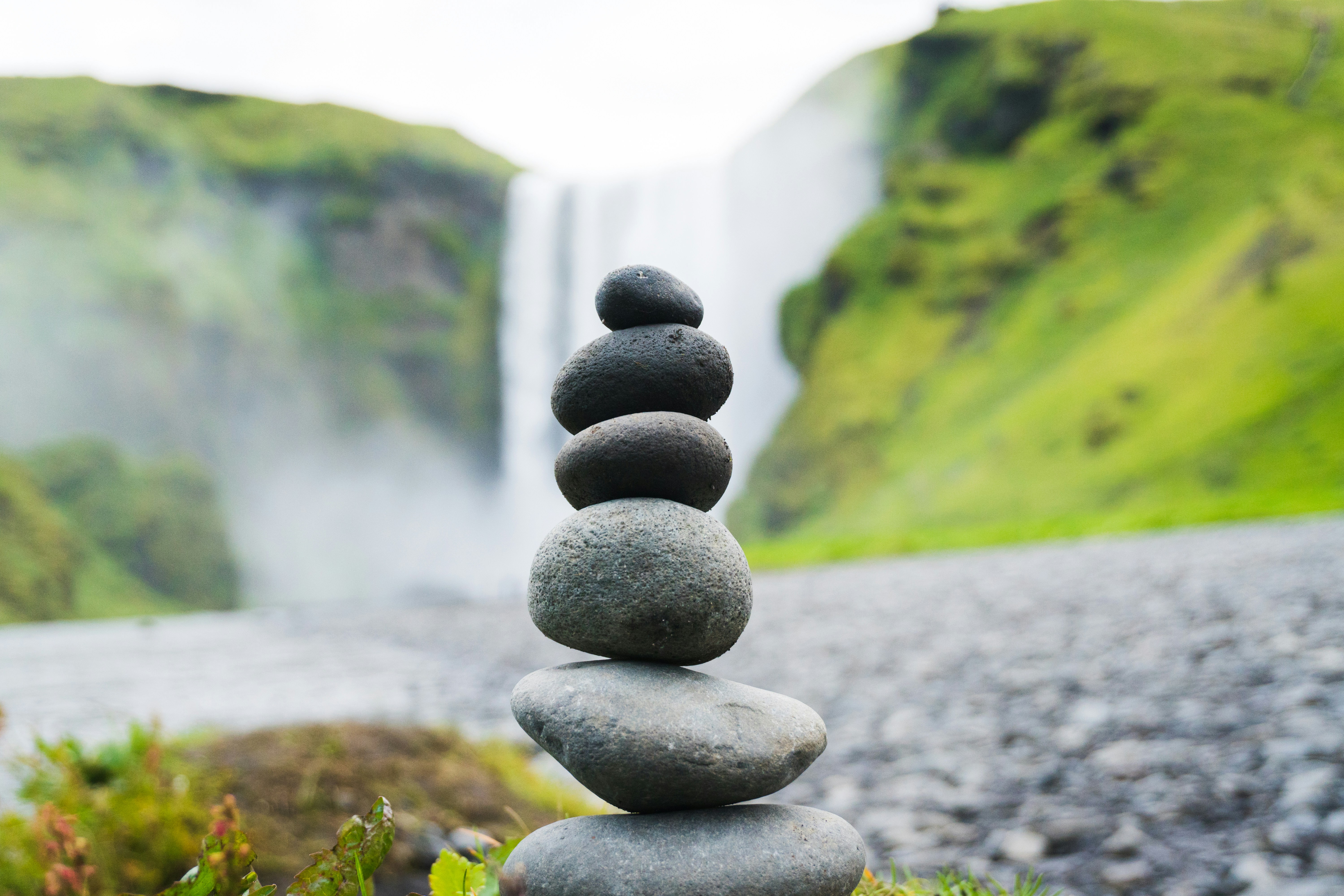 cairn stone in front of Skogafoss Falls, Iceland