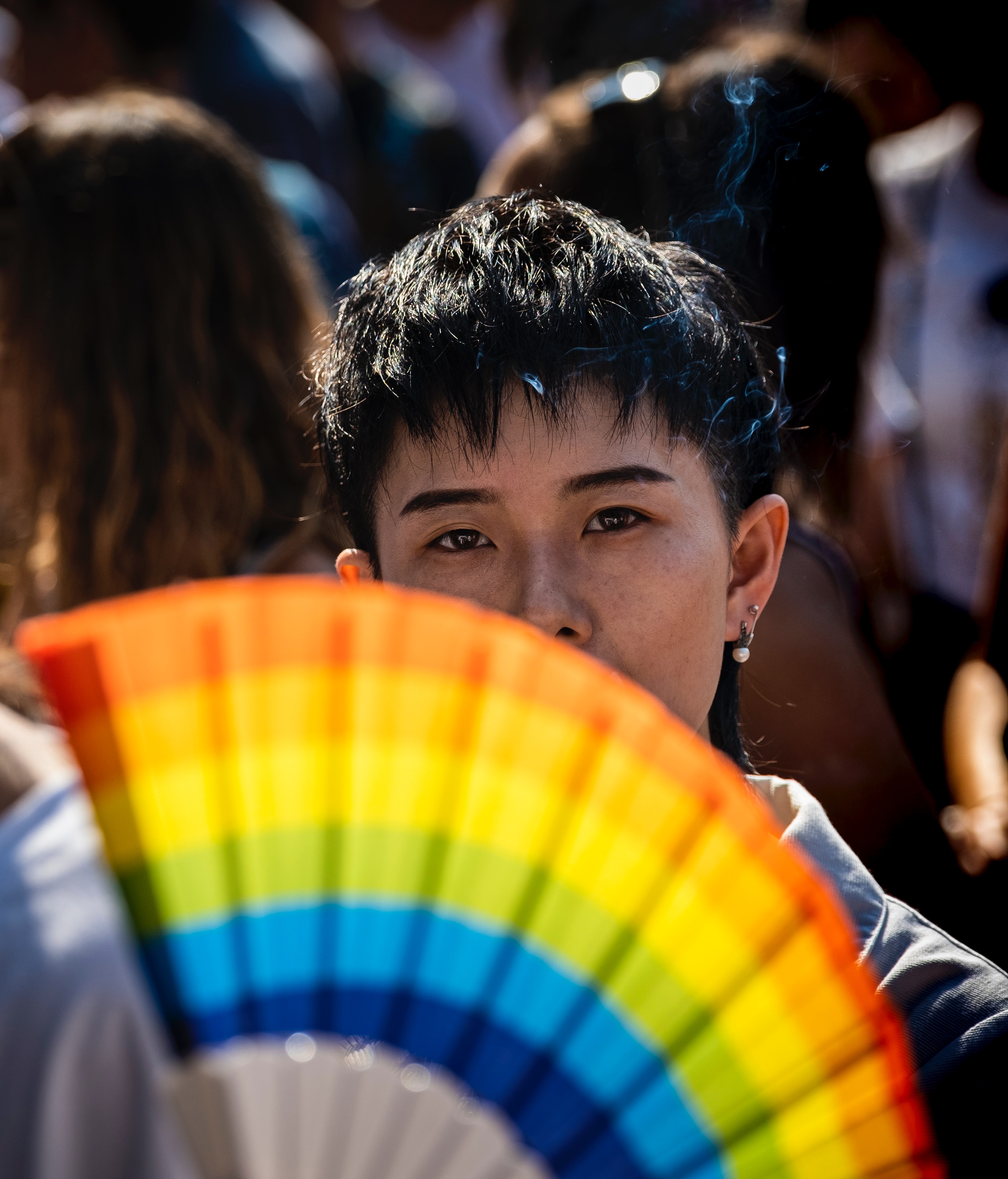 A person holding a rainbow fan