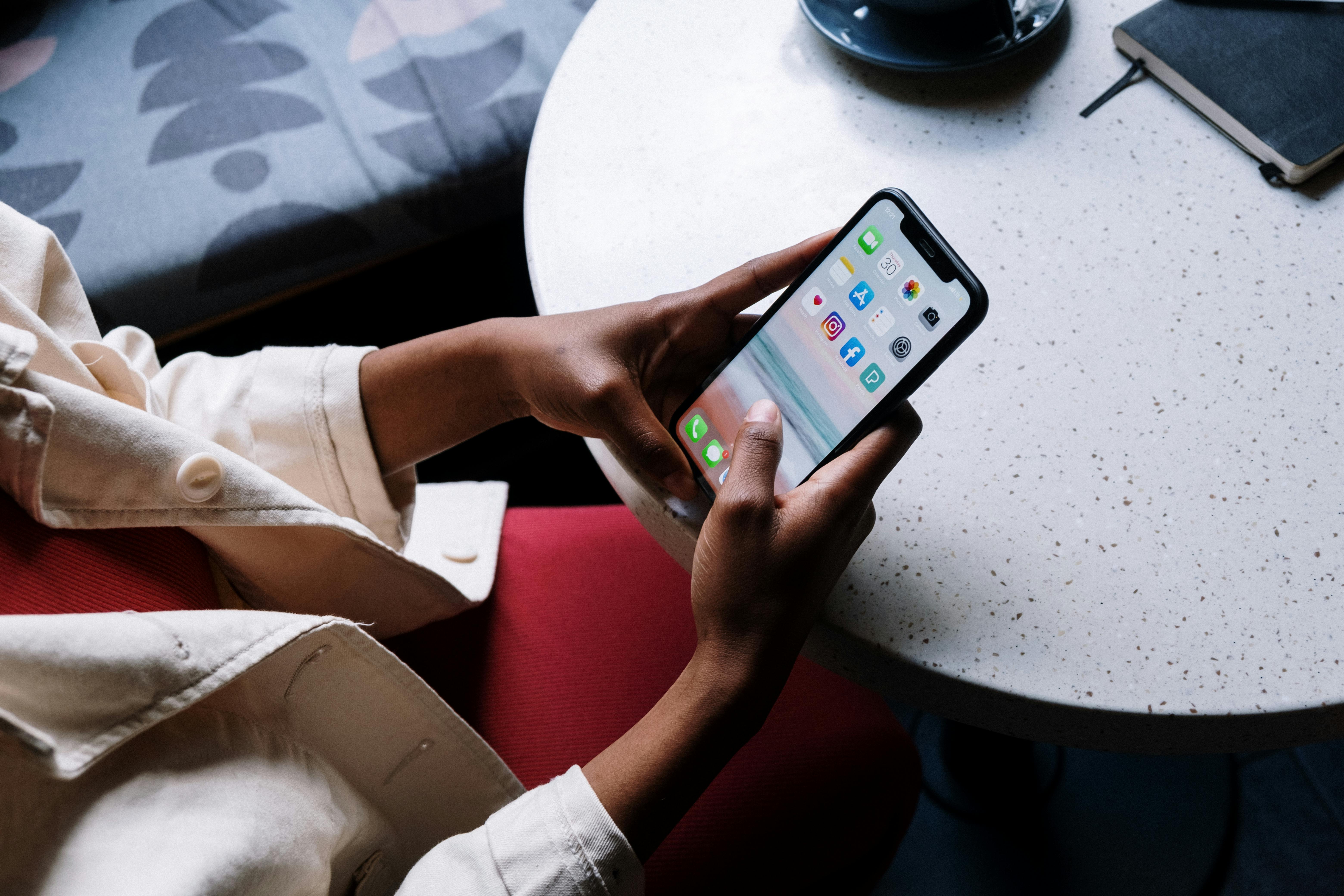 Person looking at social media icons on an iphone