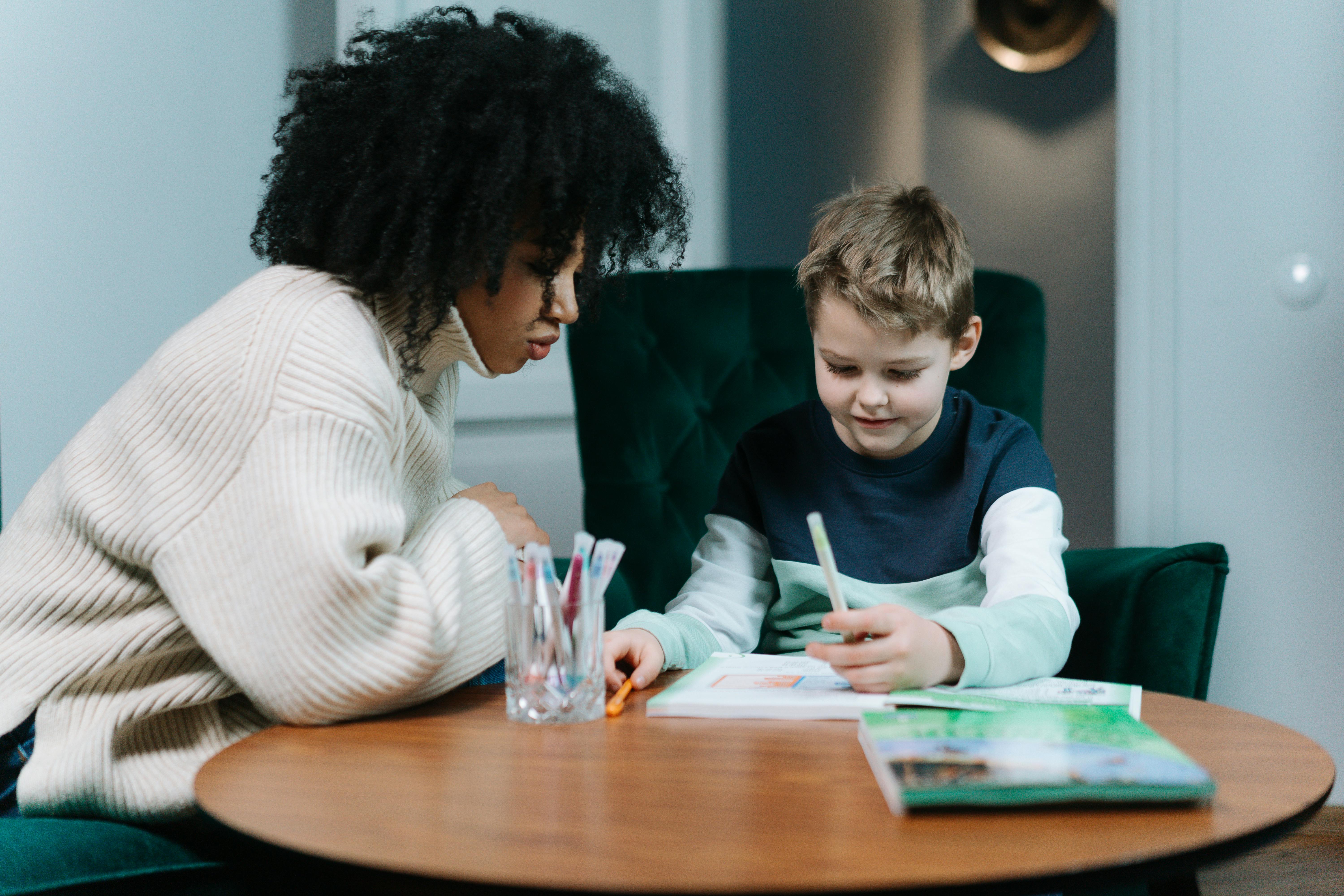 A woman helping a child with homework