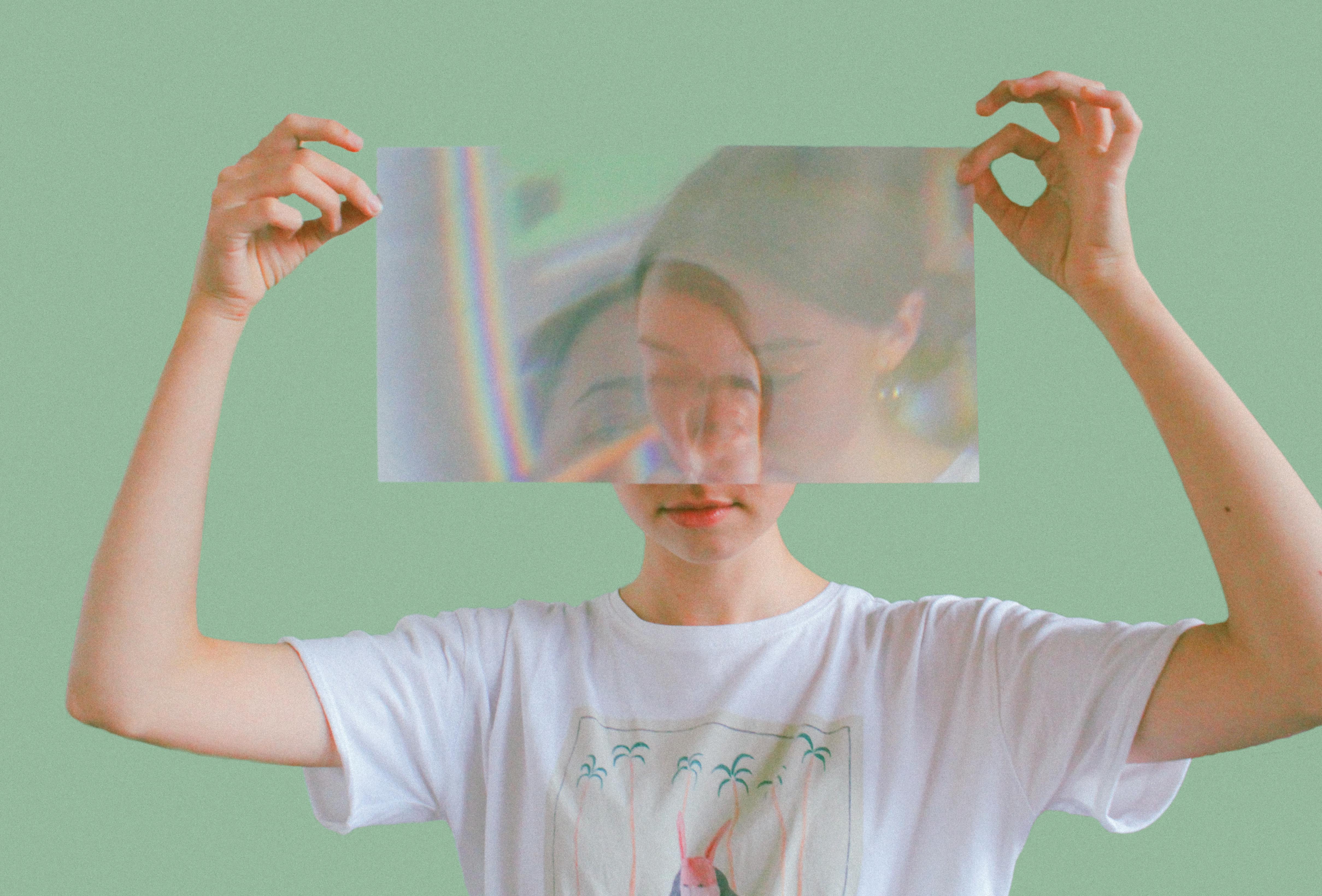 A woman holding a reflective sheet in front of her face like a mask