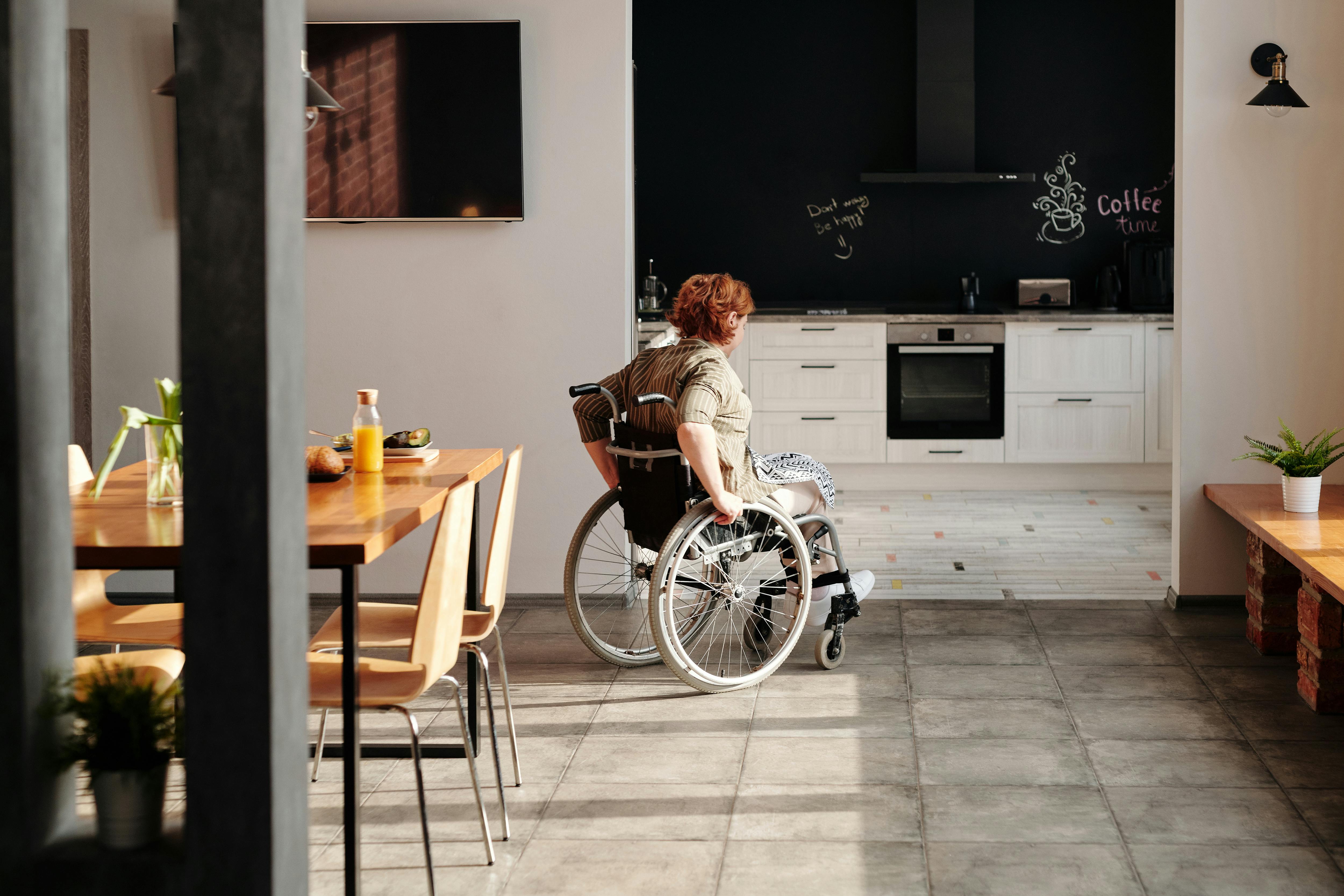 Photo of a Woman in a Wheelchair Going into the Kitchen