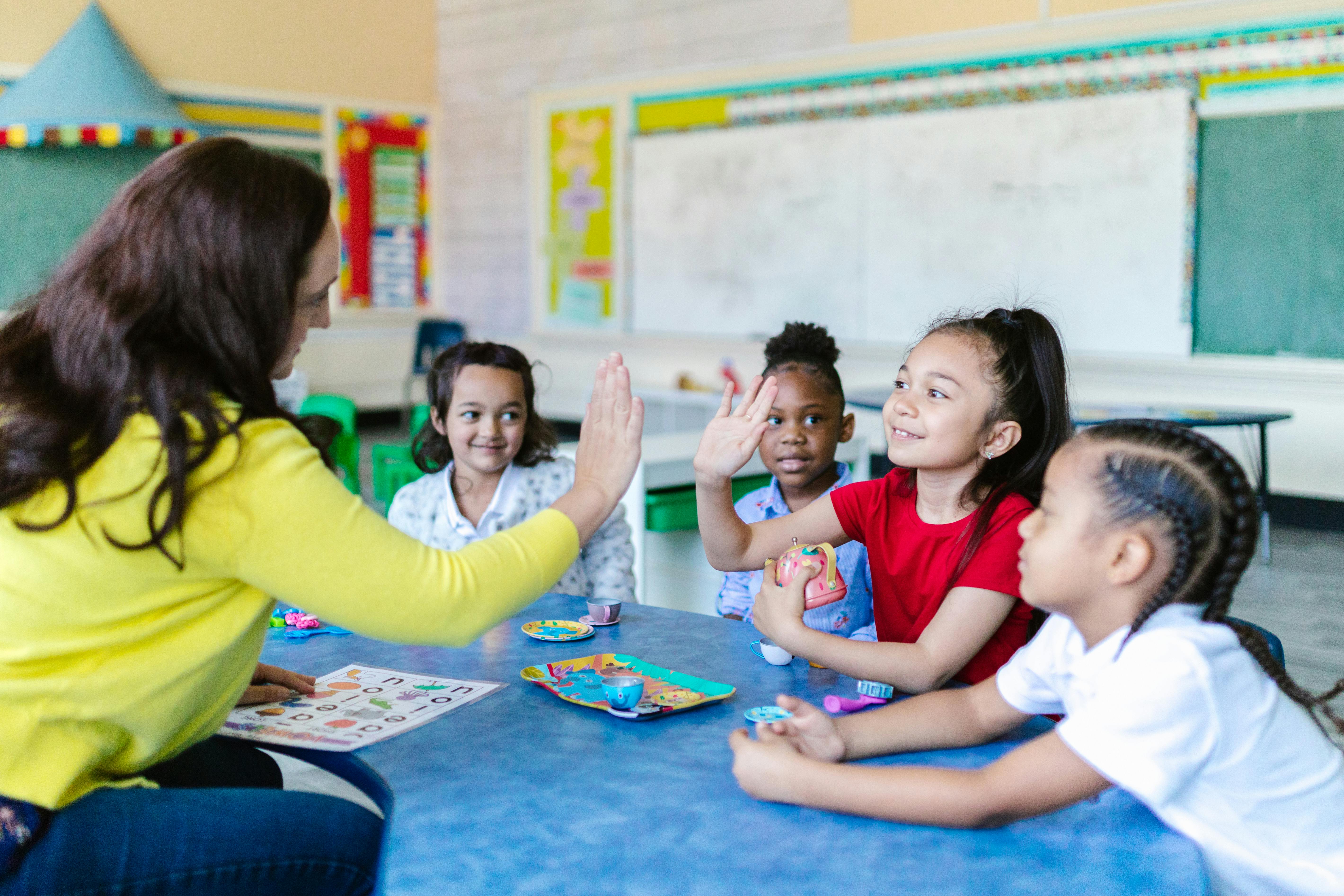A Teacher giving a student a high five in a classroom