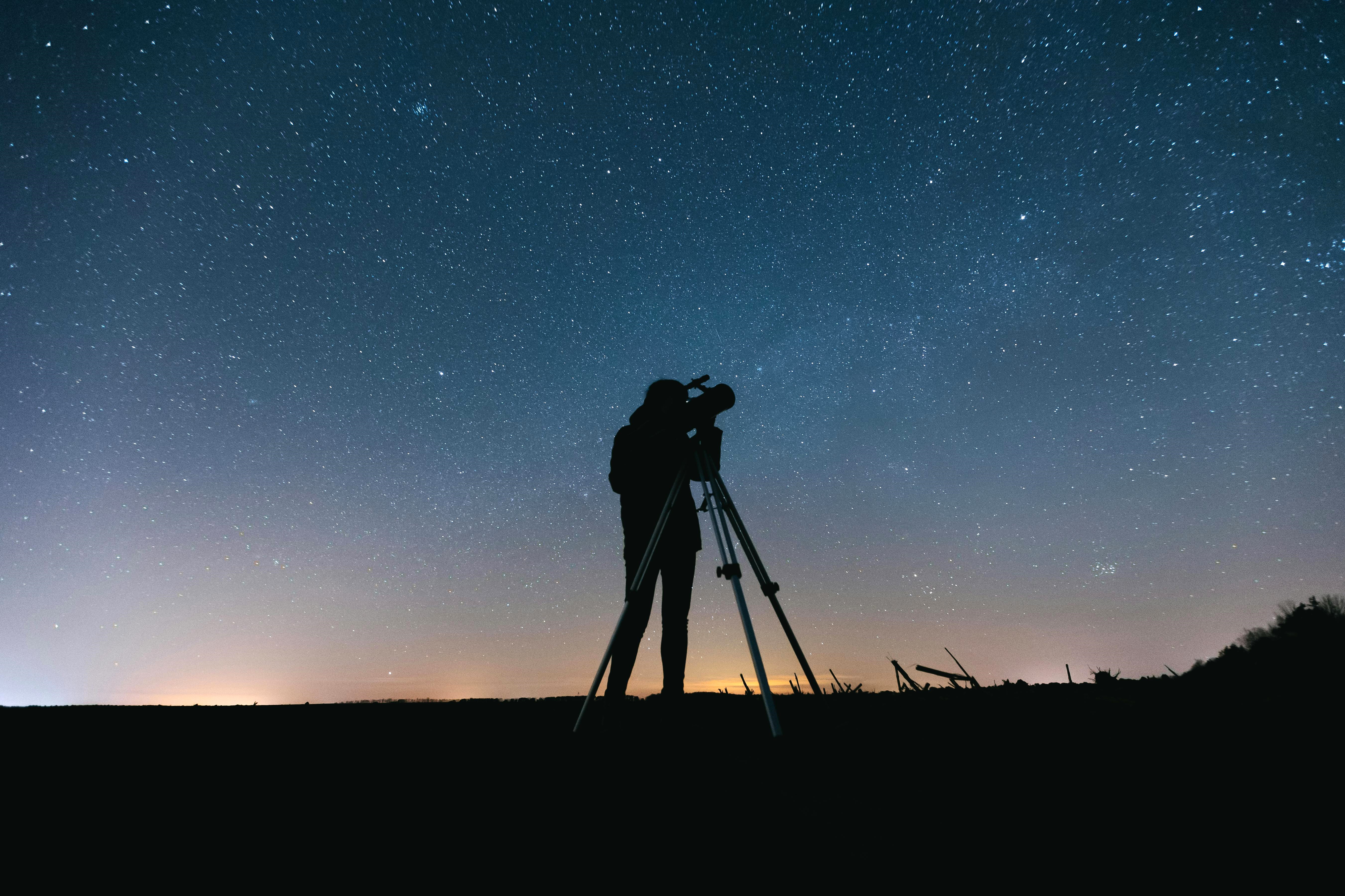 Silhouette of Person using a telescope on a Starry Night