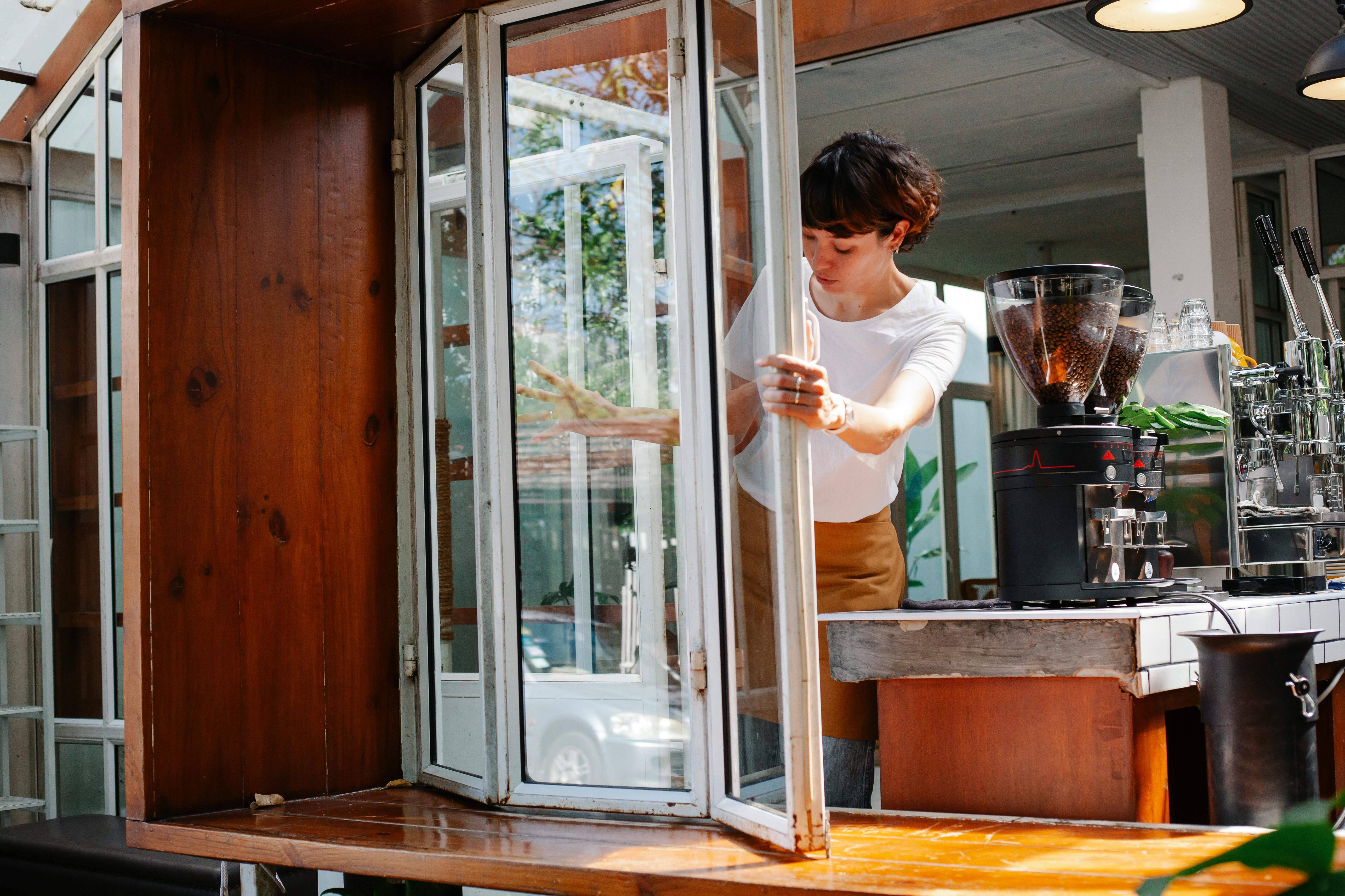 Focused woman opening window in cafe