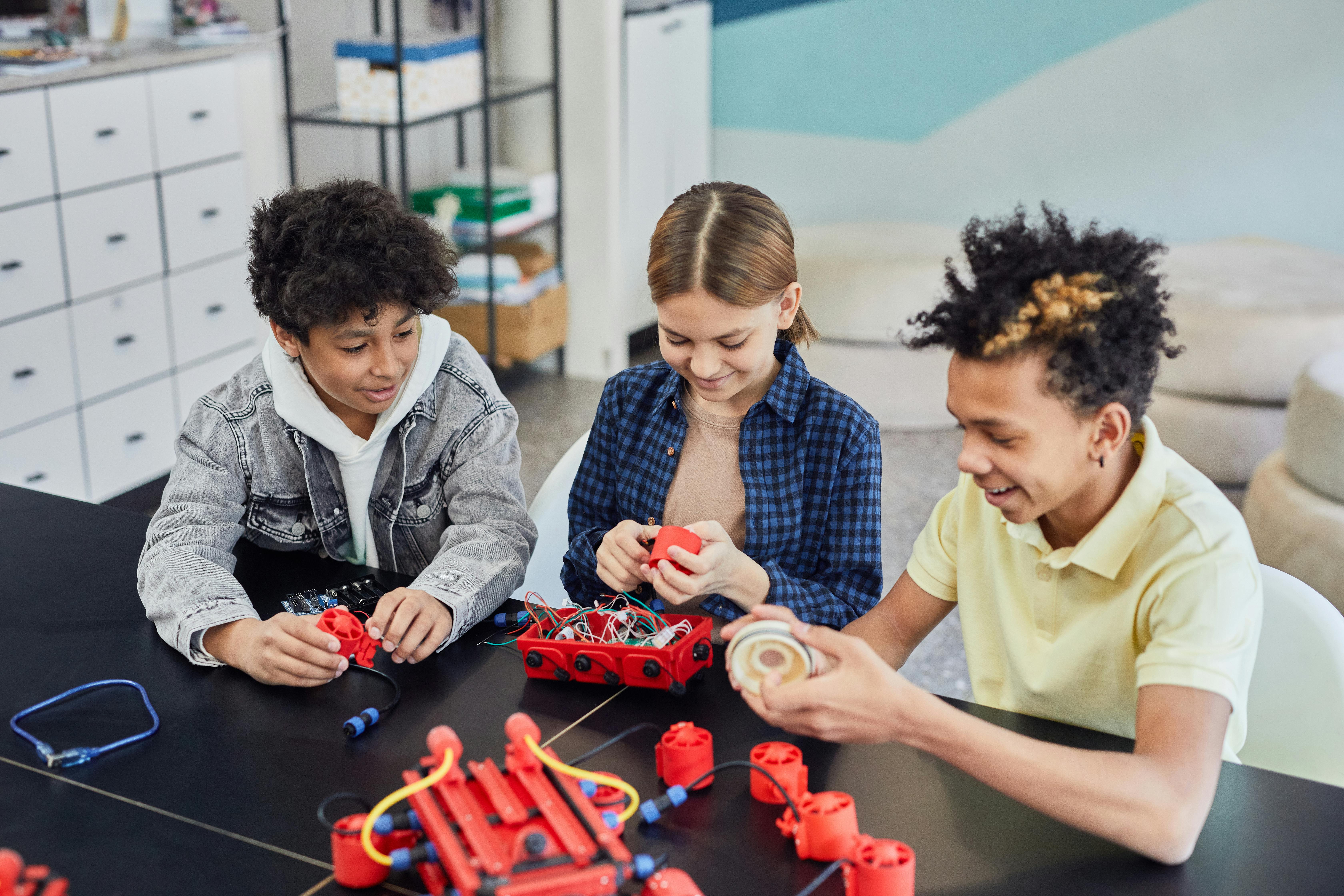 A group of teens working on a robotics kit together