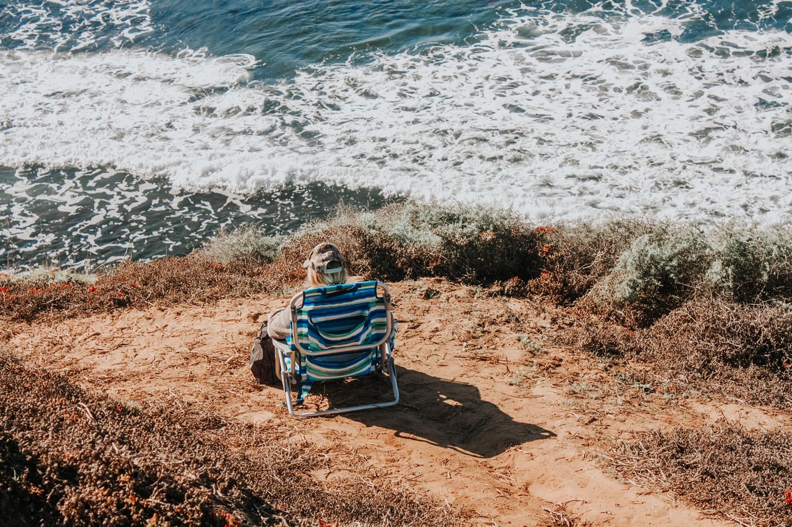 A person sitting in a chair by the seaside