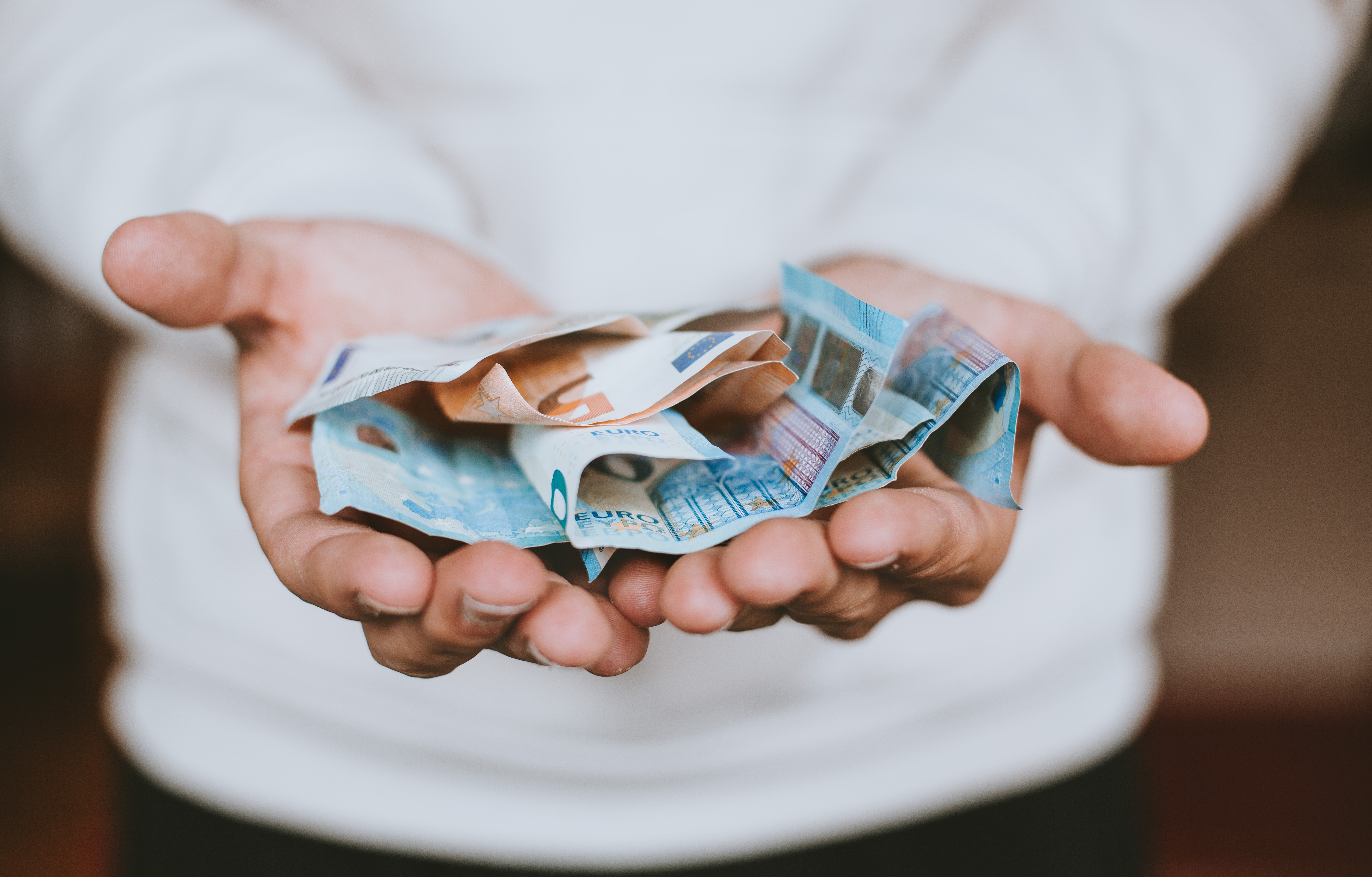 A person holding dollar bills in their hands