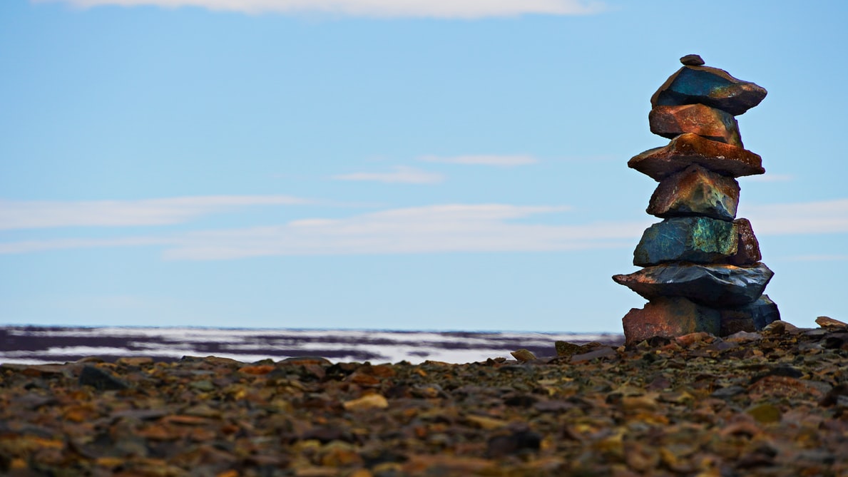 Pile de roches devant un paysage de toundra.