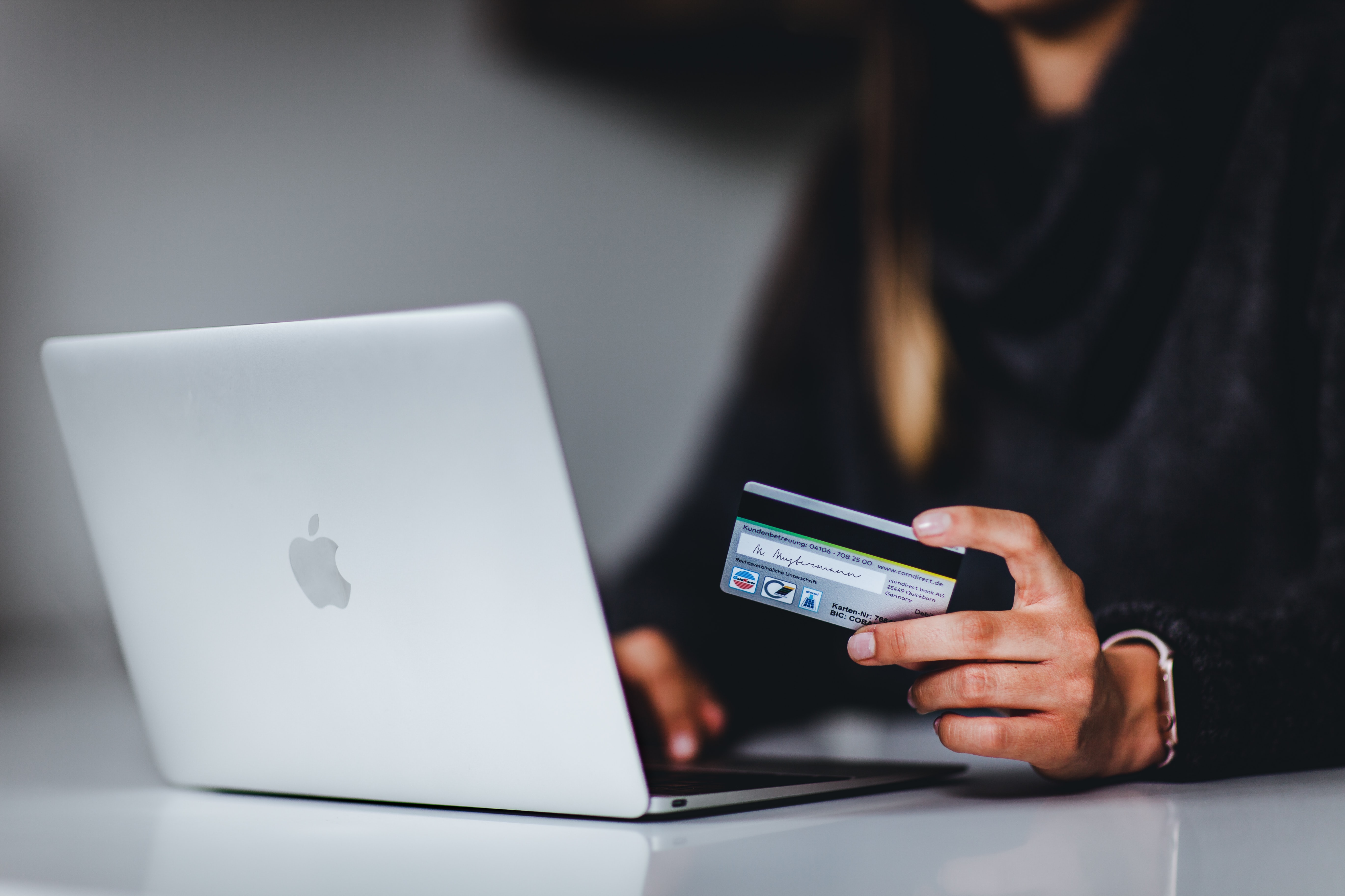 A woman entering credit card information on a laptop