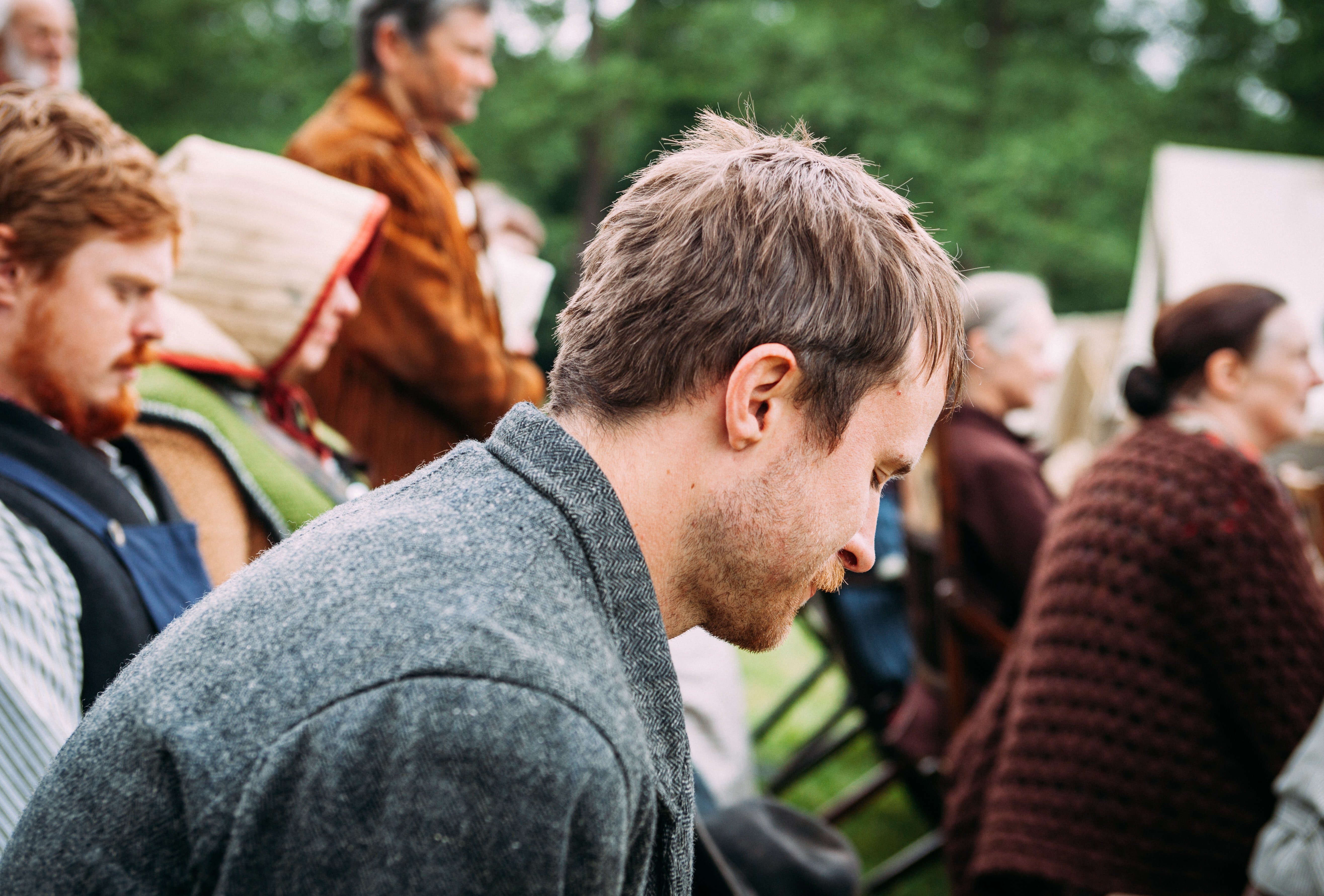 A man sitting in a crowd outside