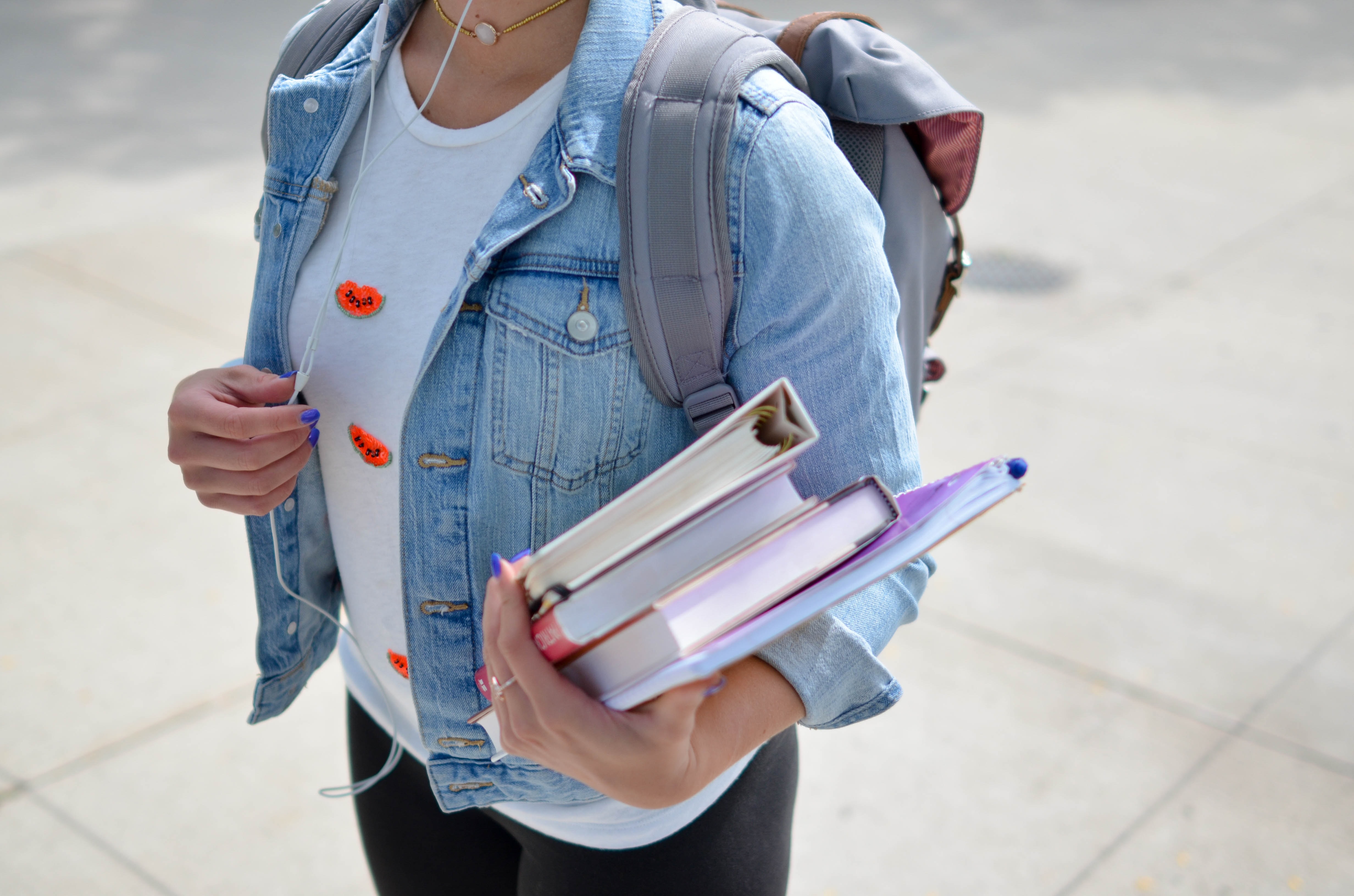 Close up photo of a female college student carrying textbooks