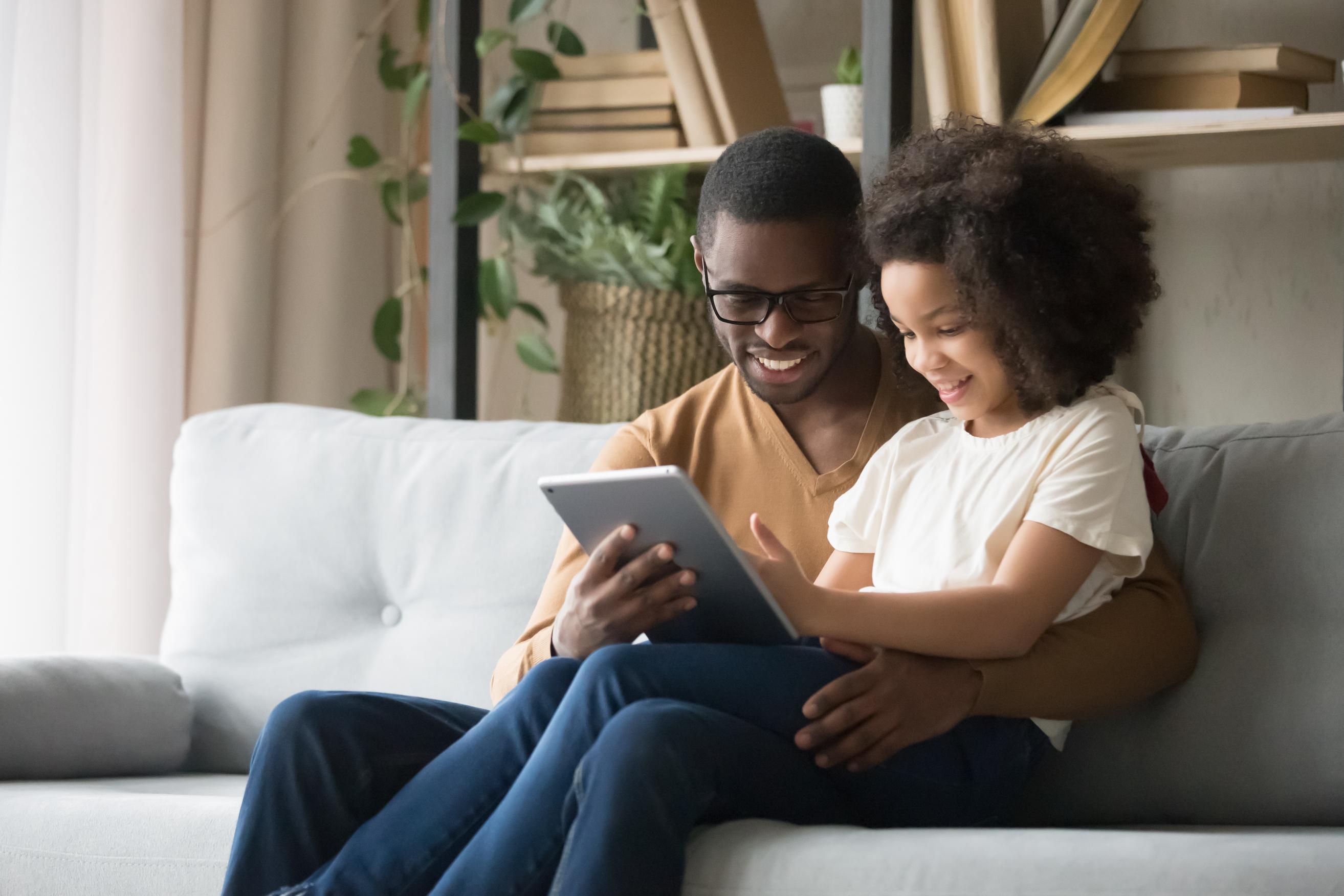 A father and daughter looking at a tablet together