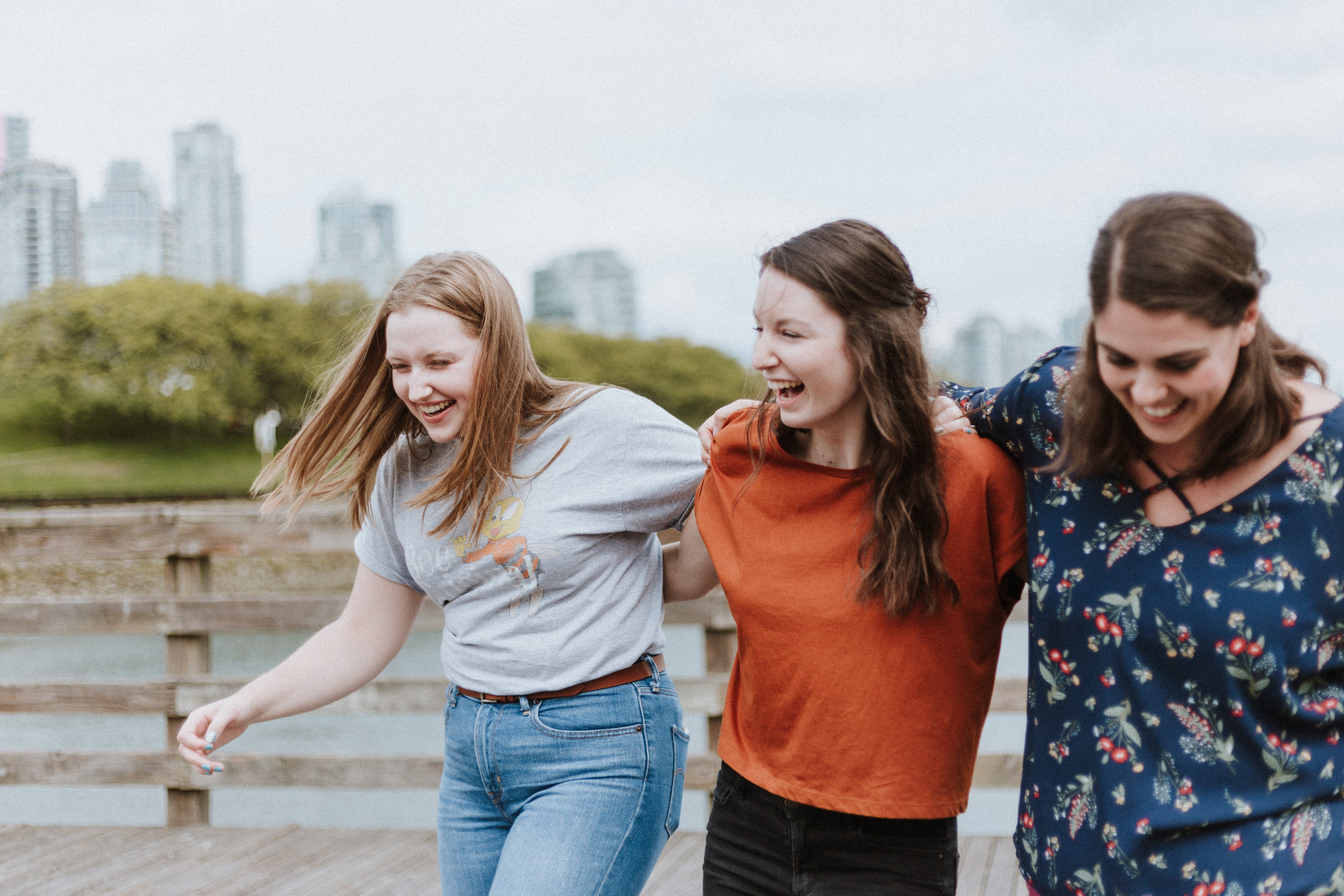 Three women walking along the shore and laughing